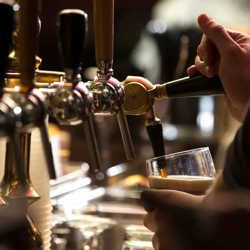 Bartender filling beer in a glass from a kegerator.